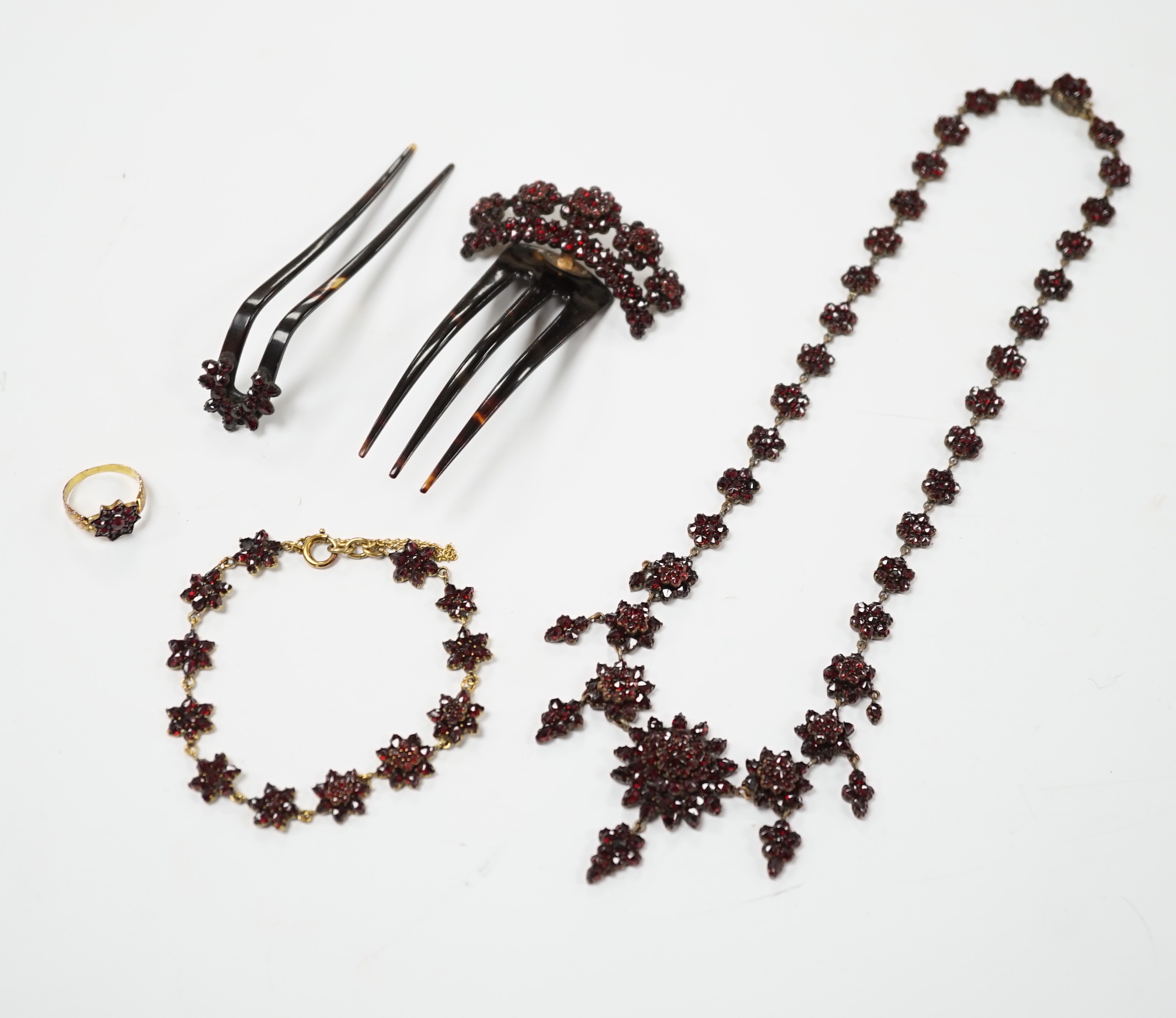 A Victorian garnet set gilt metal and tortoiseshell suite of jewellery comprising bracelet, necklace, ring and two hair combs